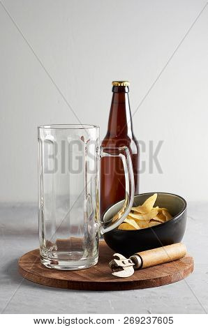Glass And Lager Beer Bottle With Potato Chips On Gray Concrete Background. Close Up View With Copy S