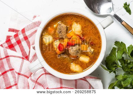 Traditional Hungarian Goulash Soup On White Stone Table. European Cuisine. Top View.