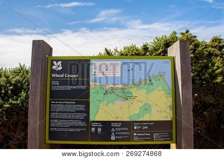 St. Agnes, England - July 24, 2018: National Trust Sign Of Stamps And Wheel Engine House Ruins Wheal