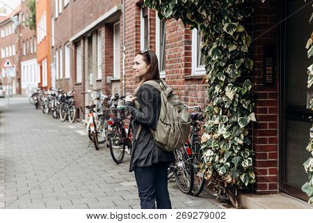 Tourist With A Backpack Is Looking For Booked Online Accommodation In An Unfamiliar City. Or A Stude