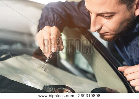 Close Up Car Glaze Worker Fixing And Repairing A Windshield Or Windshield Of A Car At A Garage Servi