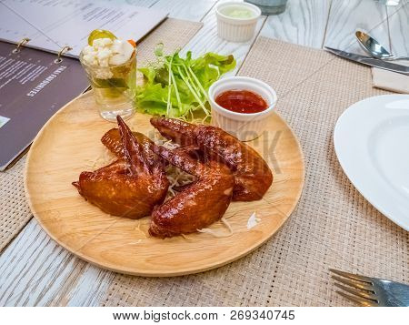 Grilled chicken wings with tomato sauce on the table in restaurant.Thai food style.