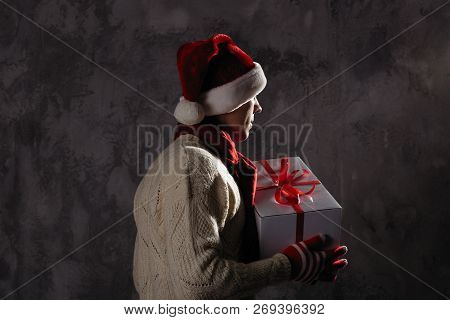 Christmas Gift Concept. Man In Santa Hat Bring Gift For You. Attractive Man Hold Box.  Christmas And