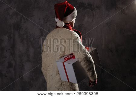 Christmas Gift Concept. Man In Santa Hat Bring Gift For You. Attractive Man Hold Box.  Christmas And