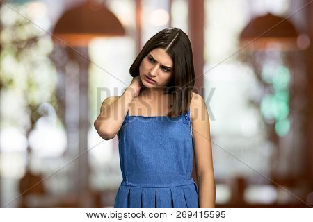 Worried Upset Woman Touching Her Nape. Young Frustrated Brown Hair Woman Having Strong Pain In Nape.