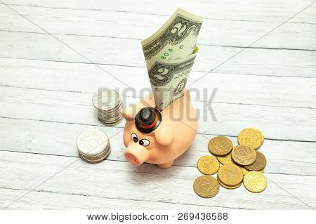 Ceramic Piggy Bank With Coins And A Dollar On A Wooden Background, Close-up