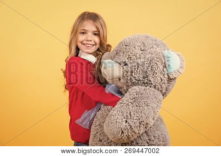 Child Smile With Grey Soft Toy. Girl Hug Big Teddy Bear On Orange Background. Holiday, Birthday, Ann
