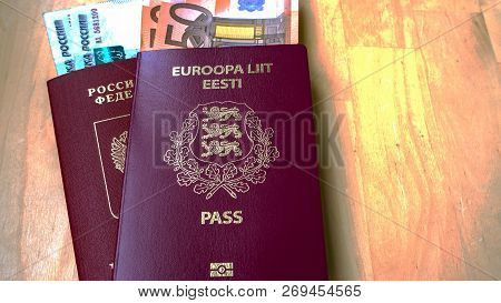 Passports On The Wooden Background. Citizenship Of Estonia And Russia. Citizenship Of European Union