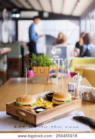 Two Mouth-watering, Delicious Burgers On The Wooden Table Small Wooden Stick Inserted In The Burgers