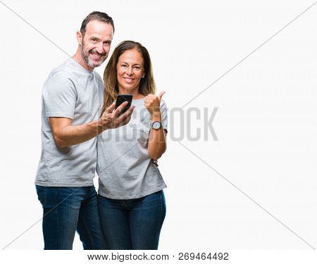 Middle age hispanic couple texting message on smartphone ver isolated background happy with big smile doing ok sign, thumb up with fingers, excellent sign