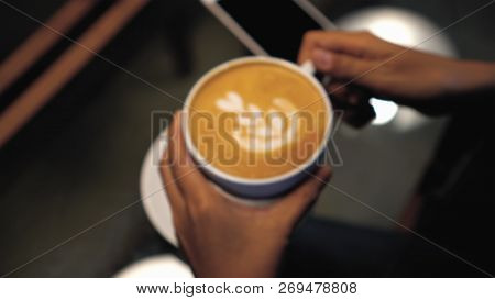 Photo Blurred Of Woman Hand Holding The Latte Art On Top In Coffee Cups At The Coffee Shop Or Book S