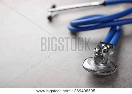 Stethoscope For Checking Pulse On Gray Table, Closeup. Space For Text