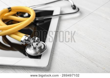 Stethoscope For Checking Pulse And Tablet On Light Table, Closeup. Space For Text