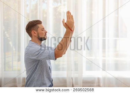 Muslim Man With Misbaha Praying Indoors. Space For Text