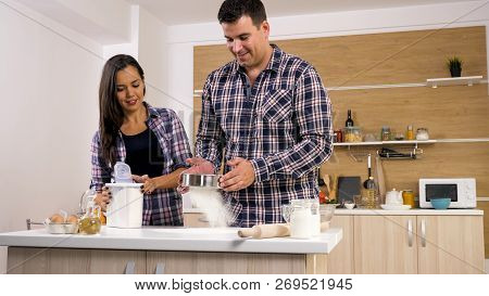 Happy Young Couple Have Fun In Modern Kitchen Indoor While Preparing