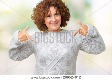 Beautiful middle ager senior woman wearing winter sweater over isolated background looking confident with smile on face, pointing oneself with fingers proud and happy.