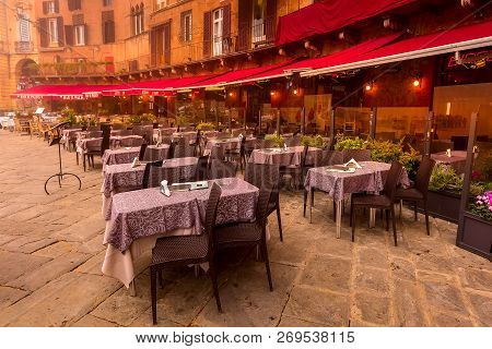 Siena, Italy - October 25, 2018: Cafe And Restaurants Tables At Campo Square Or Piazza Del Campo Wit