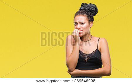Young braided hair african american with pigmentation blemish birth mark over isolated background looking stressed and nervous with hands on mouth biting nails. Anxiety problem.