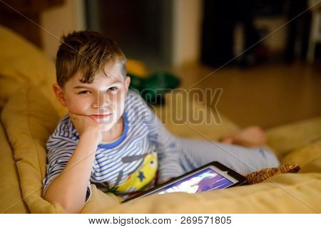 Little School Kid Boy Making Homework With Tablet. Schoolchild Reading And Learning With Computer, S