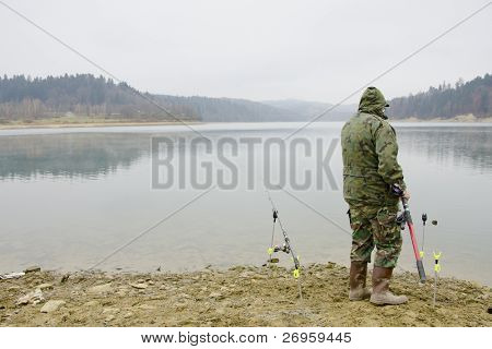 Rybář v listopadu (Solina jezero, Bieszczady, Polsko)