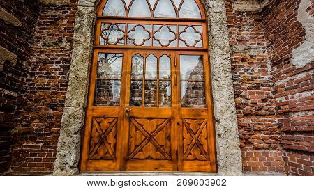 Brown And Red Brick Wall Textured Background And Wooden Door And Arch