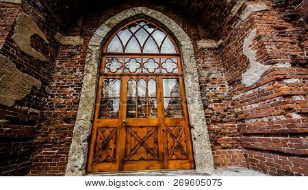 Brown And Red Brick Wall Textured Background And Wooden Door And Arch