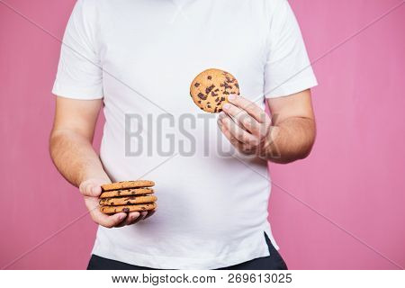 Overweight, Sugar Addiction, Imbalanced Ration, Eating Fast Food. Obese Man With Stack Of Chocolate 