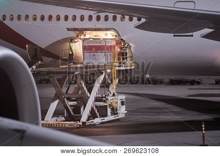 DUBAI, UNITED ARAB EMIRATES - SEPTEMBER 6, 2018: Emirates Boeing 777 Airliner ground handling at Dubai Internation Airport, loading unit load devices into the cargo hold.