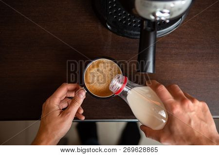 Photo Of Coffee Maker, Mans Hands Pouring Milk Into Mug Of Coffee In Kitchen