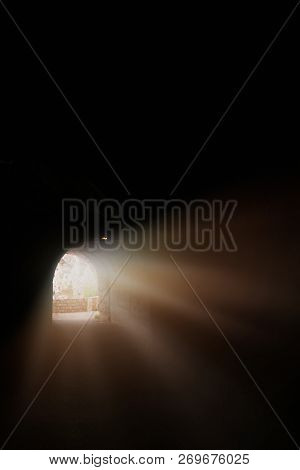 Sunlight And Sunrays Getting Into The Long Dark Tunnel Cut Through The Rock On A Sea Coast