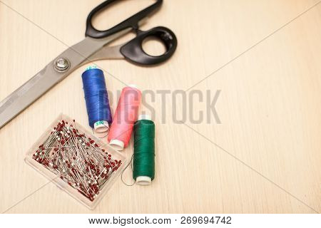 On The Cutting Table Lie Scissors, Thread And Pins. Work Place Of Seamstress. Topp View, Place For T