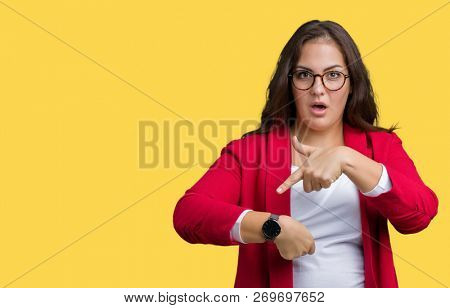 Beautiful plus size young business woman wearing elegant jacket and glasses over isolated background In hurry pointing to watch time, impatience, upset and angry for deadline delay
