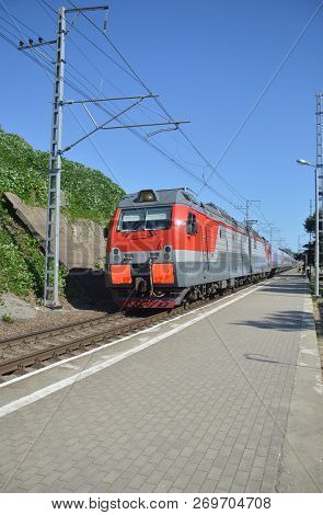 The Locomotive Carries A Passenger Train Near Railway Station