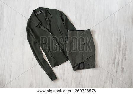 Olive Green Blouse And Skirt On Wooden Background. Fashionable Concept
