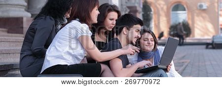 Group Of Fellow Students With Books And Laptop
