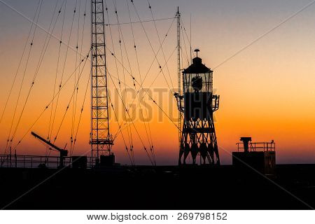 Abstract Photo With Industrial Character Of A Lighthouse Against A Brightly Colored Sky With Beautif