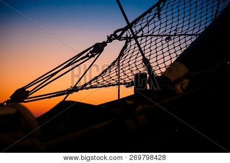Ropes, Nets, Cables, Pulleys And Bollards As Shadows Against A Colorful Sky Of Red And Blue Colors O