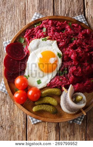 Traditional Labskaus Recipe Of Potato, Corned Beef And Beet With A Fried Egg And Herring Close-up On