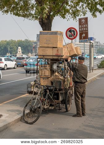 Tianjin, China - 22 October 2018: Local Chinese Man With Overloaded Bike On Bridge In Tianjin