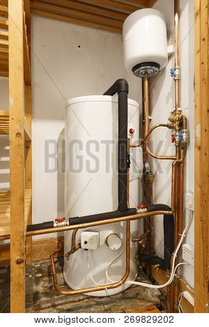 Unvented Hot Water Cylinder And Expansion Vessel In An Airing Cupboard. Uk Plumbing