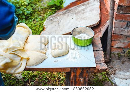 The Woman In Oversleeves Cooks Dough For Home-made Bread On Open Air