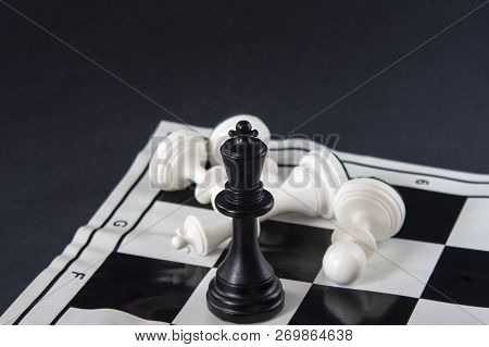 Black Chess King Standing On Chessboard, White King Fallen With Pawns. Strategy, Finance, Business C
