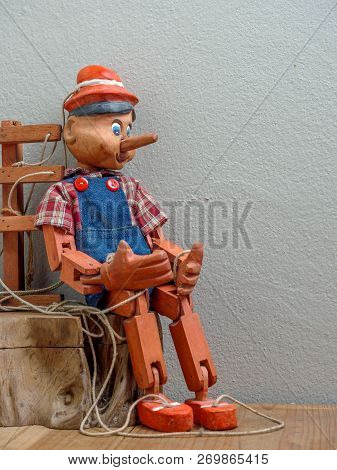 Pinocchio Puppet Made From Wood.sitting On Wood Box