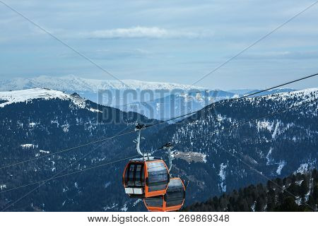 Orange Gondola Cabins Of Cableway Lift On Winter Snowy Mountains Background Beautiful Scenery