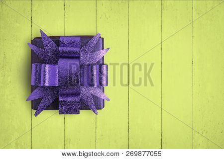 Purple Box On Yellow Wood Taable Background.