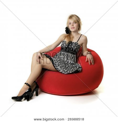 Image of the blonde girl, who sits in a red chair