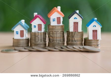 Mini House On Stack Of Coins,money And House,  Mortgage, Savings Money For Buy House And Loan To Bus