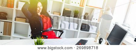 A Beautiful Young Girl Leaned Back In Her Office At The Table.