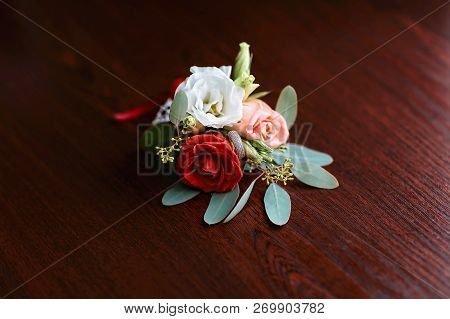 Wedding Accessories Of The Budo Of Red, White And Pink Flowers For The Groom With A Ring On A Dark W