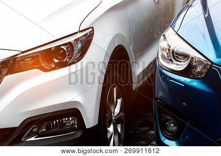 Close Up Headlamp Light Of Blue And White Suv Car Parked On Concrete Parking Lot Of The Hotel Or Sho